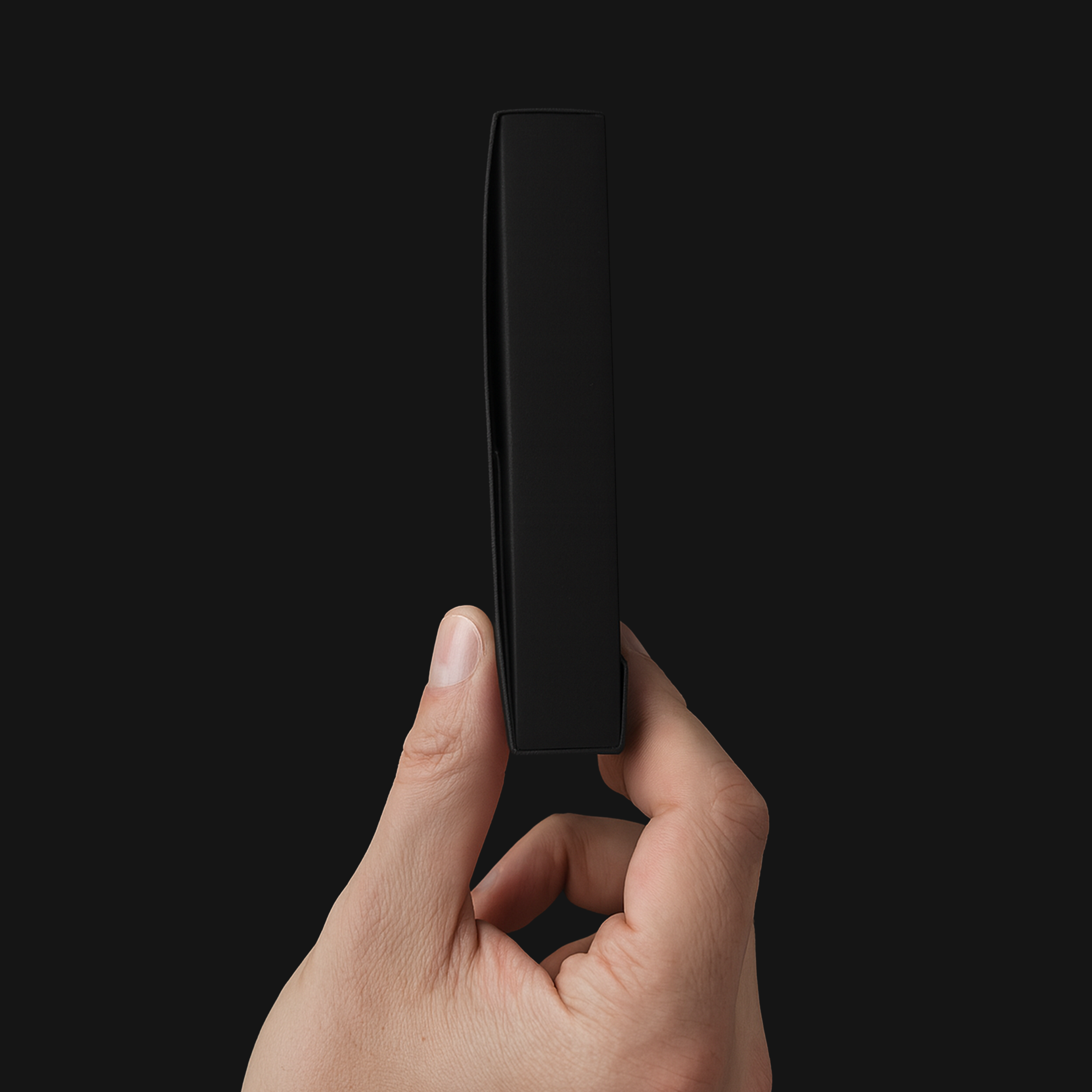 Hand holding a PullShield graded card shipping case shown from the side against a black background highlighting the thickness of protection.